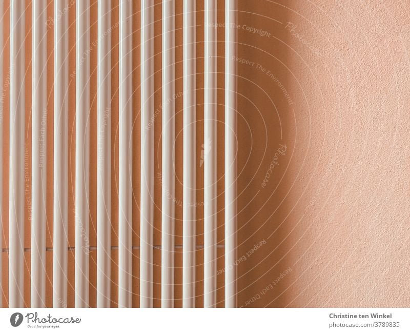 Vertical tubes of a radiator on a light apricot coloured wall with light and shadow Heater Pipe Wall (building) Shadow Shadow play apricot-coloured White