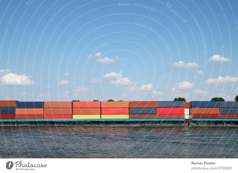 Cargo ship with numerous colorful containers on a river blue business cargo commercial crane delivery dock export freight goods harbor import industrial