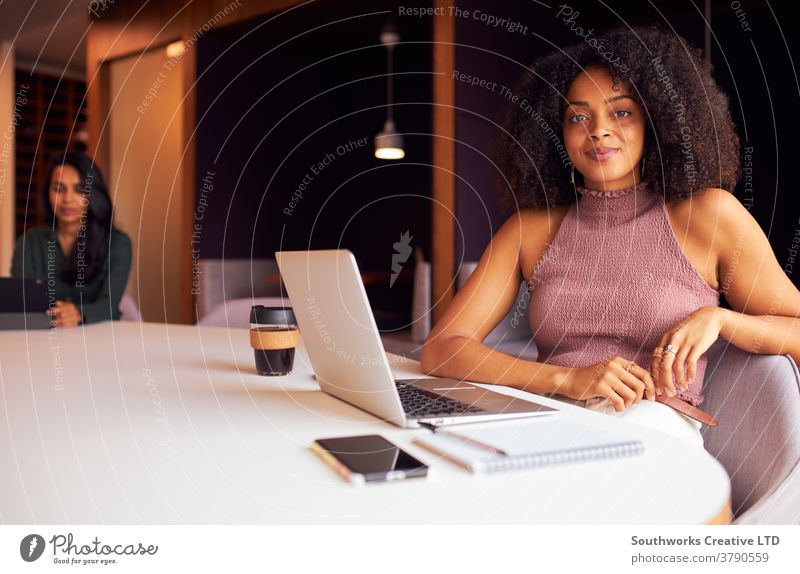 Portrait Of Businesswoman With Laptop At Socially Distanced Meeting In Office During Health Pandemic business businesswomen meeting social distancing