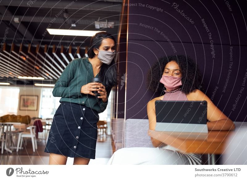 Businesswomen Wearing Masks Having Socially Distanced Meeting In Office During Health Pandemic business businesswomen meeting face mask face covering ppe