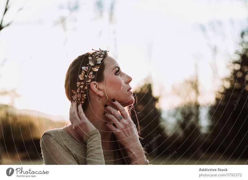 Charming woman in copper wreath touching neck gently in nature charming touch neck sensual pleasant serene gentle tender sensitive trendy gorgeous grace