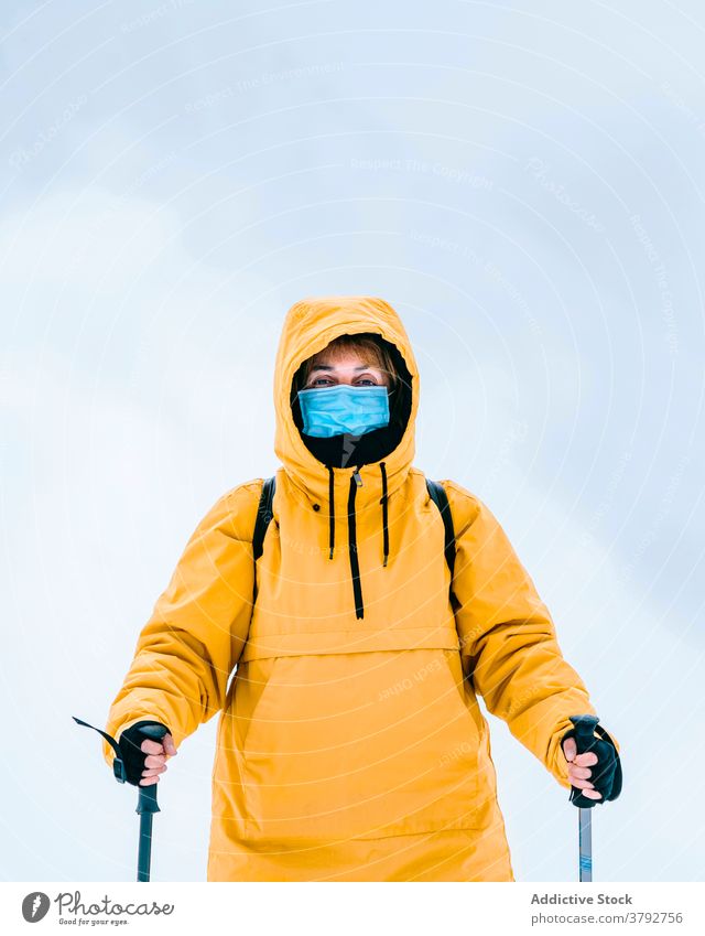 Active traveler in warm wear and medical mask in snowy mountains hiker trekking covid19 coronavirus active adventure female covid 19 pandemic freedom nature