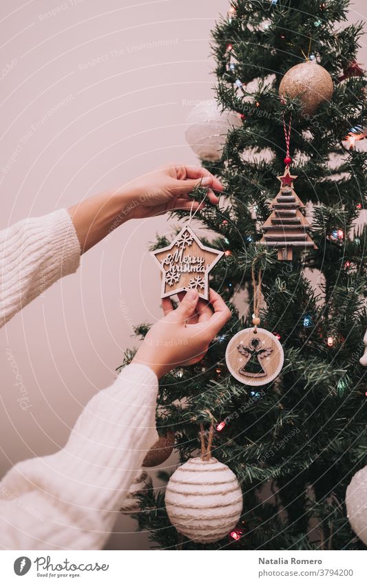 A person is decorating the Christmas tree. The person is hanging a Christmas star with a Christmas greeting. Close Up. christmas decorative celebration