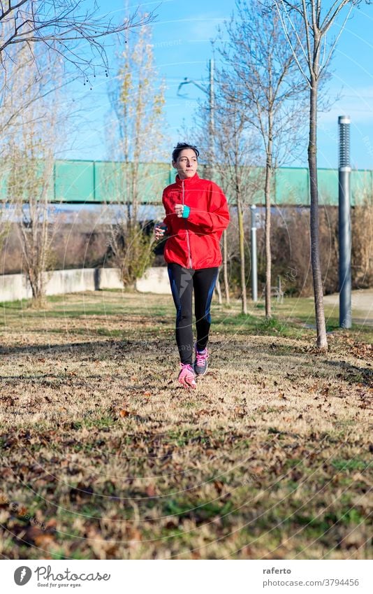 Front view of a fitness girl training running in the morning park exercise jogging woman nature runner jogger lifestyle 1 sport person autumn female active wear