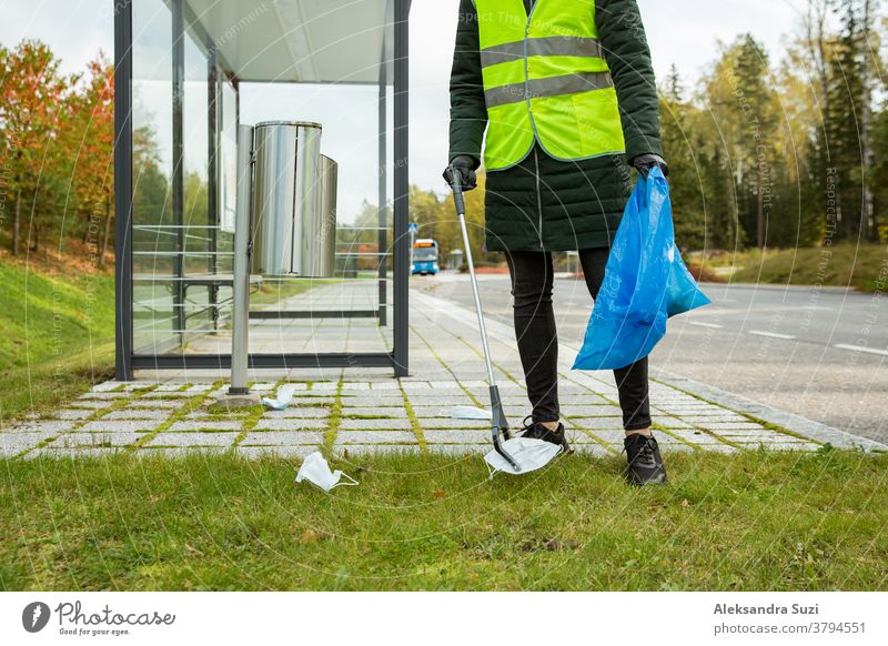 Coronavirus garbage. Volunteers collecting used disposable medical masks and gloves near the bus stop and along the highway. The problem of environmental pollution during a pandemic COVID-19