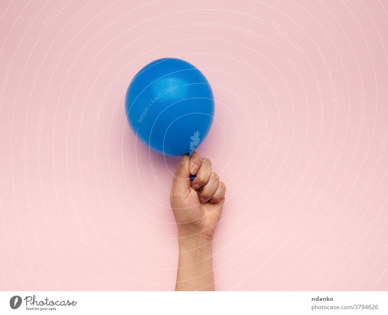 female hand holding an inflated blue air balloon anniversary arm background ballon birthday blank caucasian celebration closeup decoration festive filled float