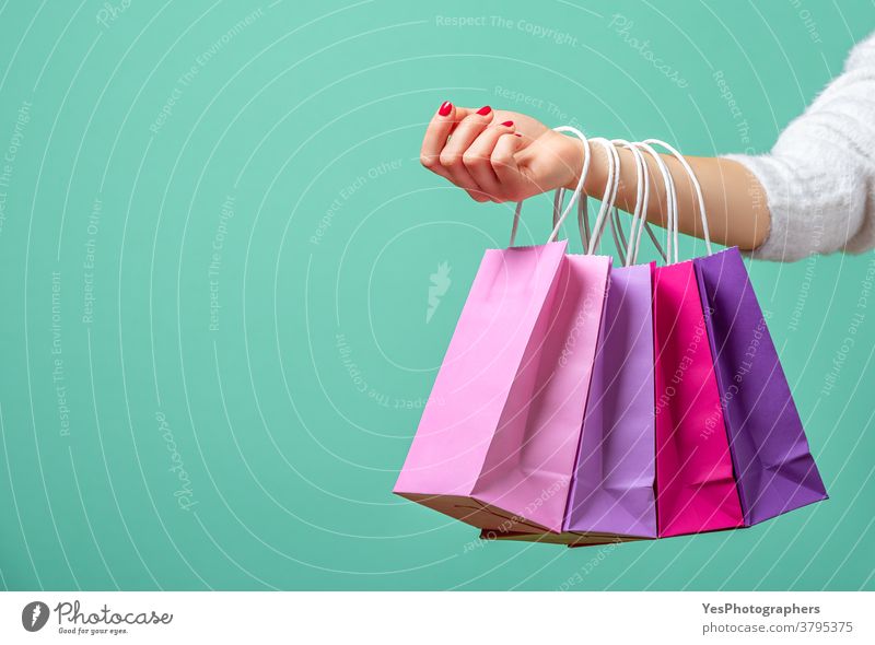 Shopping bags on womans hand. Woman shopping with colored paper bags. alone aqua arm background black friday blue buy carrying christmas close-up colorful