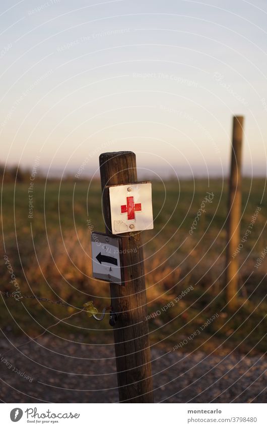 Reference to first aid when hiking Exterior shot Colour photo Detail Arrow Signage sign Clue First Aid Help Red red cross Metal daylight Crucifix Old Arrow left