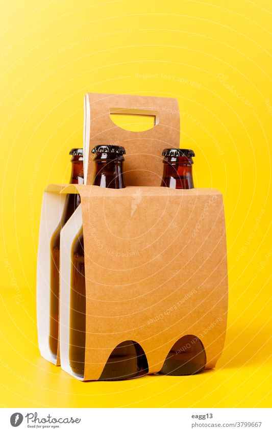 Presentation of pack of four beers with yellow background ale bavarian belgian beverage booze bottle bottles box brand branding brewery carton case container