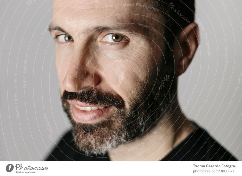 Close-up portrait of a handsome bearded middle-aged man against neutral background studio confident grey guy face isolated adult lifestyle cool indoors mature