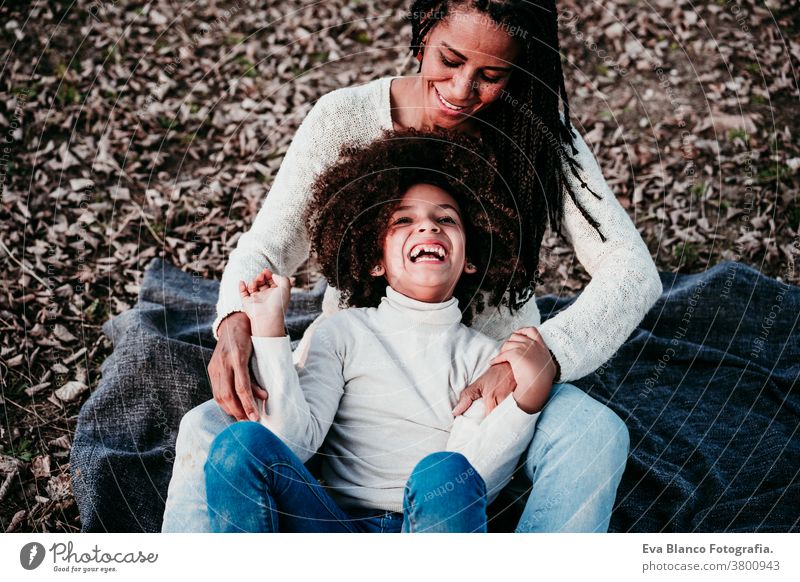 hispanic mother and afro kid girl playing outdoors relaxing in nature. Autumn season. Family concept daughter family mixed race motherhood childhood parenthood