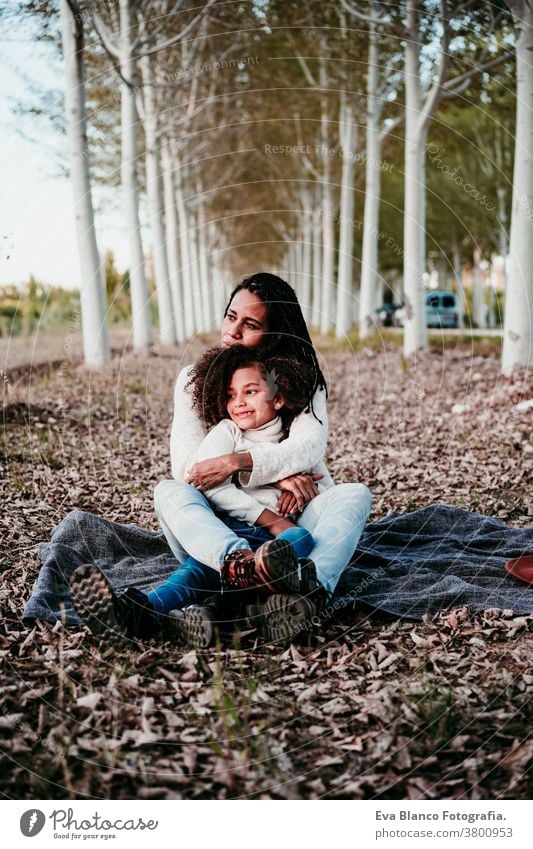 hispanic mother and afro kid girl outdoors relaxing in nature. Autumn season. Family concept daughter family mixed race motherhood childhood parenthood
