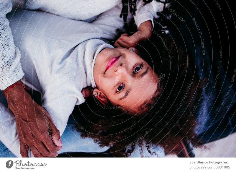 top view of afro kid girl with her mother outdoors, autumn season, family concept portrait daughter mixed race hispanic motherhood childhood parenthood