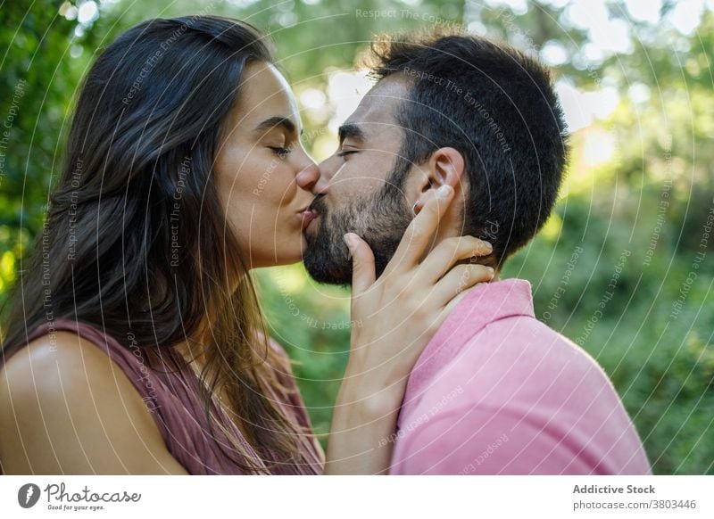 Foto de young couple kiss, boyfriend kissing girlfriend face in a park in  summer do Stock