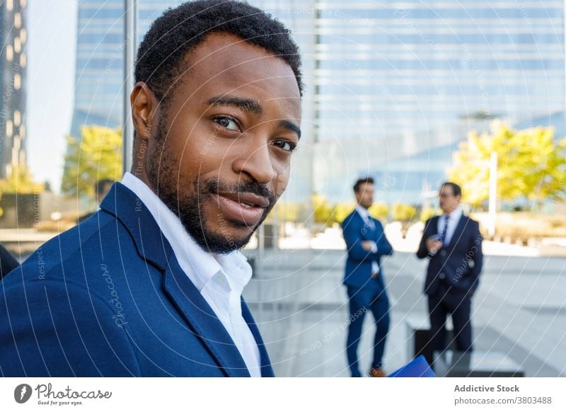 Cheerful black male employee looking at camera on street man optimist smile confident business downtown city style elegant manager businessman young