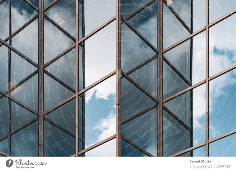 Abstract background of clouds reflected on the glazed corners of an office building facade abstract windows urban architecture edifice frontage structure