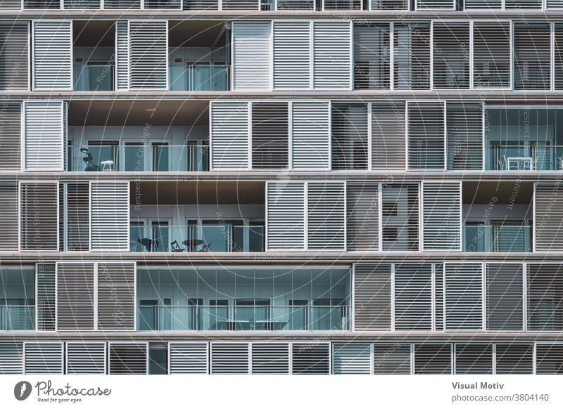 Frontal geometrical view of the shutters and balconies of an urban building arranged in continuous rows facade architecture metropolitan edifice structure