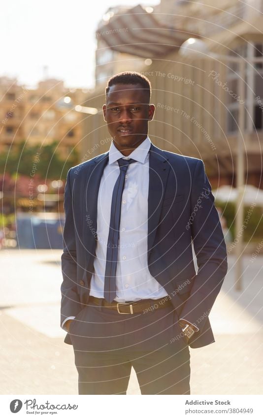 Stylish executive black man in suit walking in downtown - a