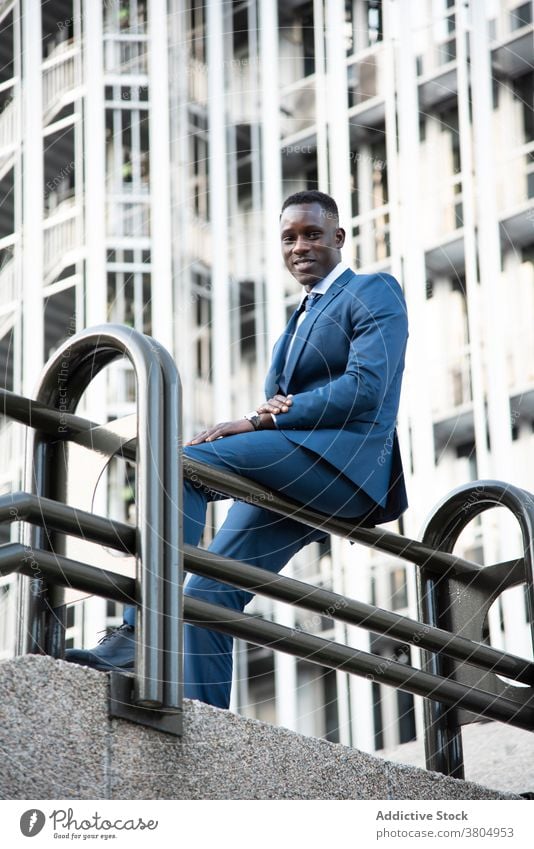 Stylish executive black man in suit walking in downtown - a