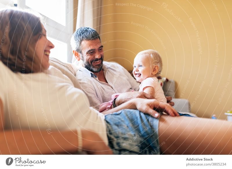 Happy mother playing with toddler family baby father cheerful happy fun sofa wife husband living room boy kid childhood parenthood affection joy motherhood