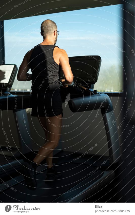 Man exercising on a treadmill with window view in the gym Moving pavement Walking Fitness centre Window sunshine Sports workout Movement Jogging inside