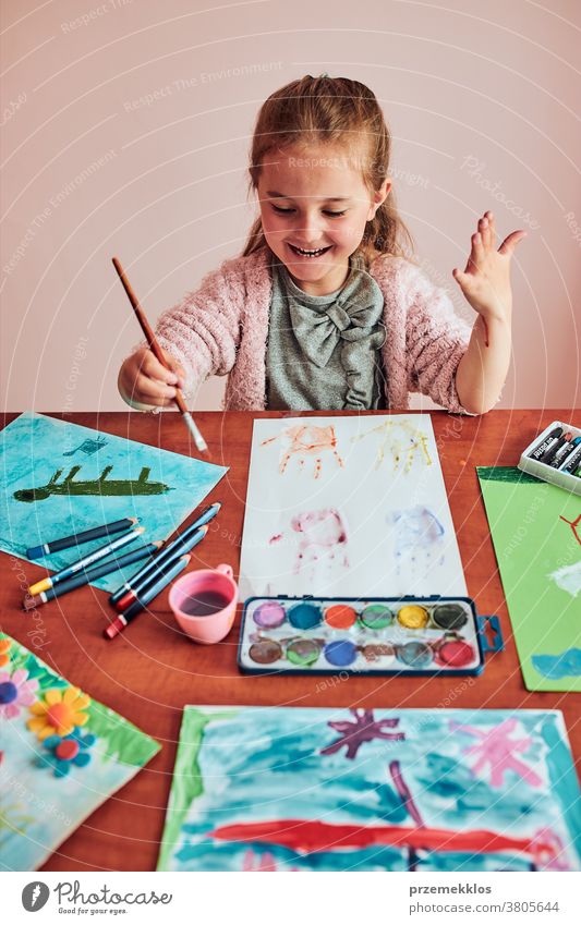 Little girl preschooler painting a picture using colorful paints and crayons child dye education art home paper childhood creation craft table creativity kid