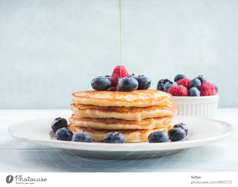 Stack of pancakes with blueberries and syrup food american stack blueberry breakfast maple syrup pour motion honey delicious fruit sweet white raspberry recipe
