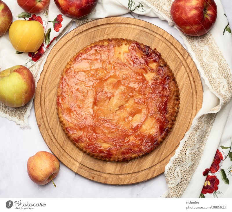 baked round apple pie on wooden board and fresh apples above cake pastry dessert homemade food american delicious thanksgiving traditional fruit sweet autumn