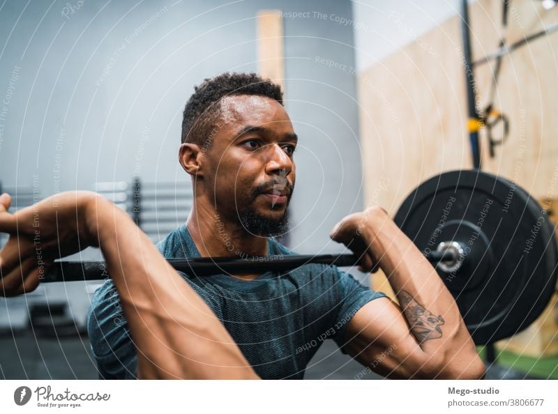 Personal trainer helping a young woman lift dumbells - a Royalty Free Stock  Photo from Photocase