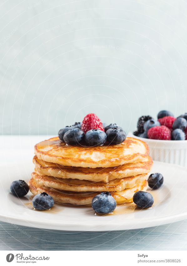 Stack of pancakes with blueberries and syrup food american stack blueberry breakfast maple syrup honey delicious fruit sweet white raspberry recipe product