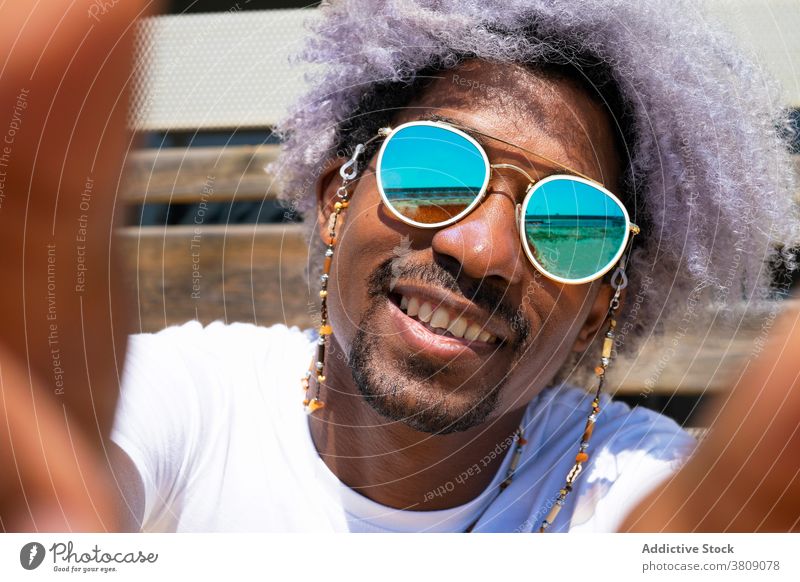 Black man with afro hair smiling and taking a selfie. Black man black man african american taking a picture portait style sunglasses smile happy happiness photo