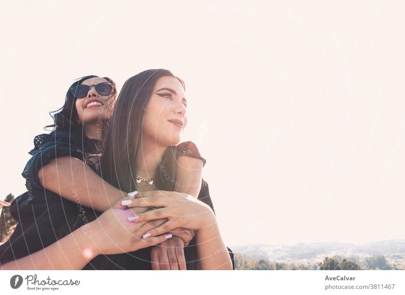 Couple of women having fun during a sunny day hugging each other with copy space friendship joy female woman happiness young beautiful woman people embracing