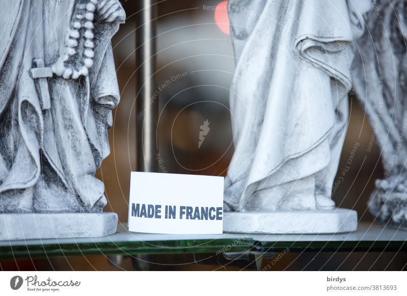 Made in France, sign in a shop window with Christian holy figures writing Shop window Figures of Saints Christianity Crucifix Belief Christian cross