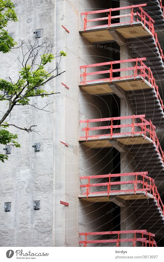 Carcass, temporary stair railings, parapet at the staircase of a high-rise building under construction House building unfinished Stairs High-rise makeshift Red