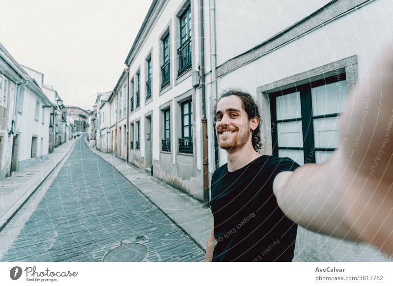 Young man with glasses taking a selfie on a old spanish street photo holiday maker modern bearded portrait cheerful happy waterfront backpack caucasian fun