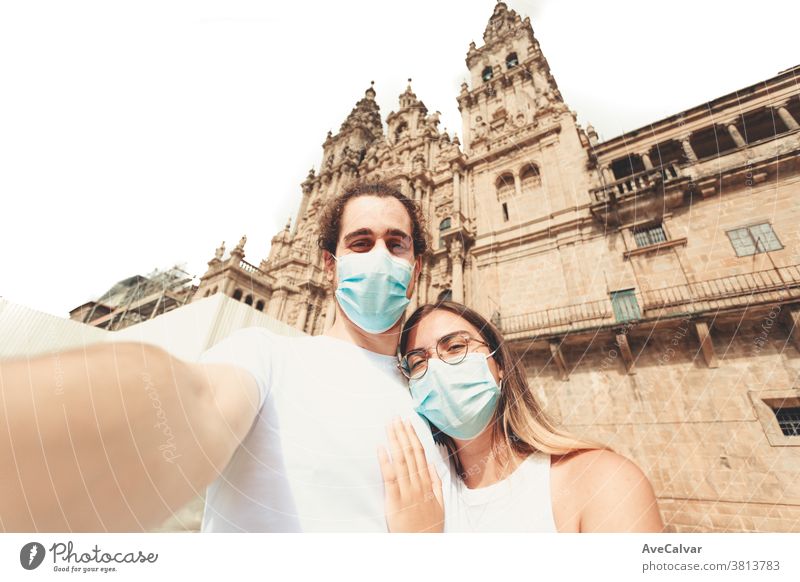 Young couple taking a selfie in a touristic place with the masks on together love young vacation boyfriend human relationships holiday friends happy travel