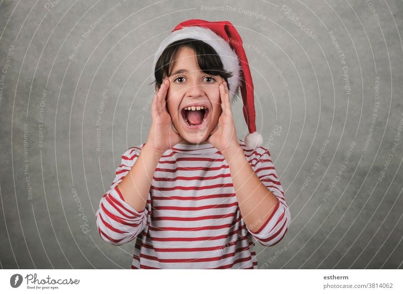 Merry Christmas, screaming kid wearing Santa Claus hat child christmas santa claus shout shouting christmas eve crazy excited announcement positive gesture