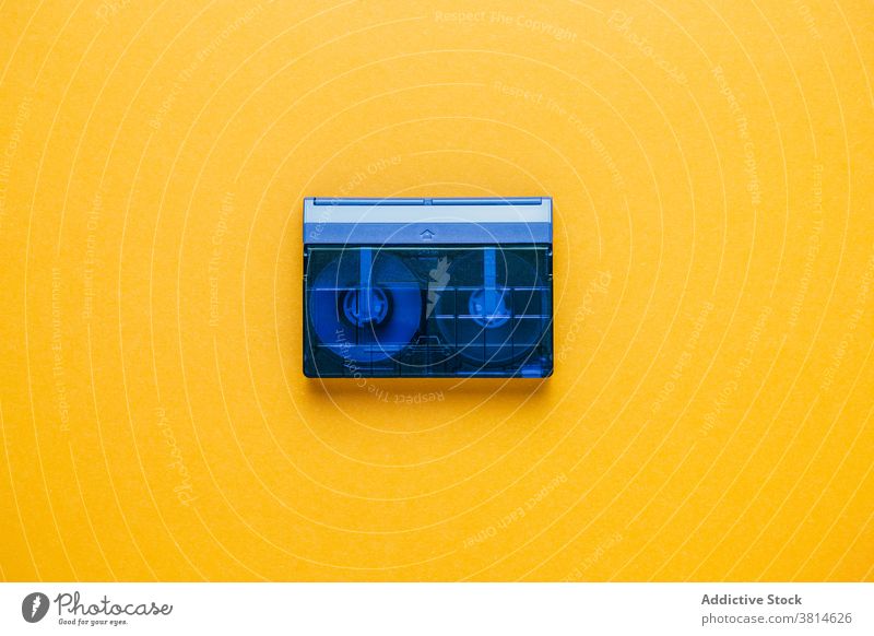 Vintage tape cassette on yellow background audio retro vintage old fashioned compact transparent analog music stereo obsolete plastic listen bright colorful