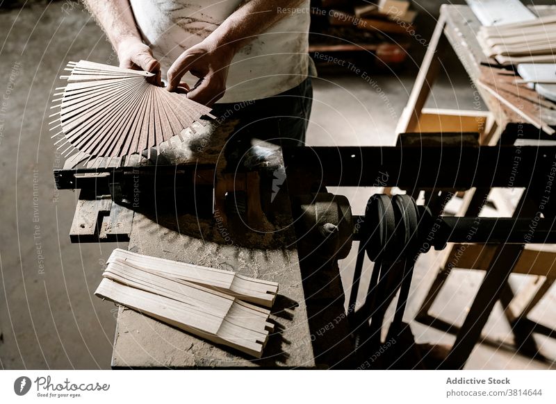 Crop artisan creating folding fan in workshop wooden man create workbench handicraft handmade male dirty craftsman job small business occupation dusty skill