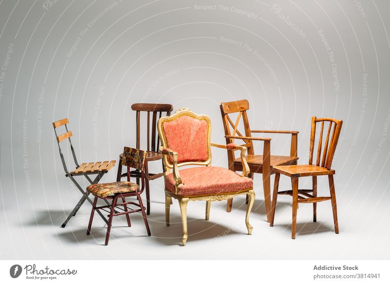 Studio shot of classical mixed chairs on neutral background furniture pile messy disordered seat wooden old-fashioned hipster minimal simplicity copy space