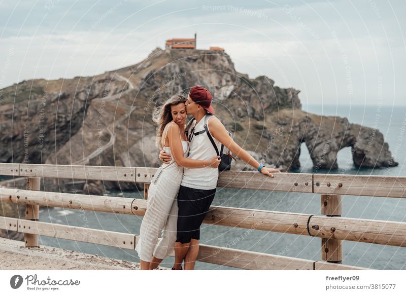 Couple of tourists in front of the Gaztelugatxe island couple tourism visiting sightseeing sightseers romantic vizcaya spain bermeo X century copy space travel