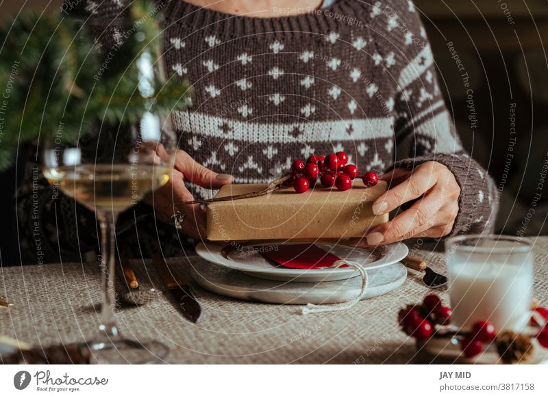 Woman opening christmas gift while sitting at table setting, Family Together Concept woman christmas table setting happy people present love holiday together