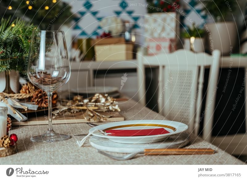 Homely christmas table setting, with pine branches rustic tablecloth in the living room of home. European style with Christmas lights. thanksgiving