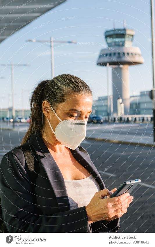 Woman in mask waiting for taxi in airport browsing woman arrive coronavirus protect epidemic traveler smartphone suitcase baggage respirator luggage tourist