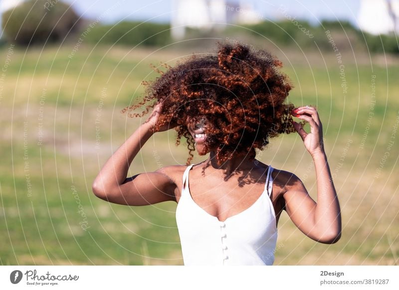 Beautiful afro american woman with white dress sitting on grass in a park in sunny day. 1 african american female young portrait outdoor person lady lifestyle