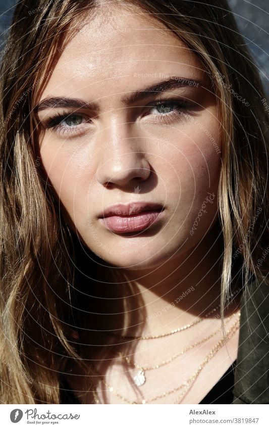 Close portrait of a beautiful girl looking directly into the camera Intensive teen kind feminine Uniqueness Exceptional natural light Looking into the camera