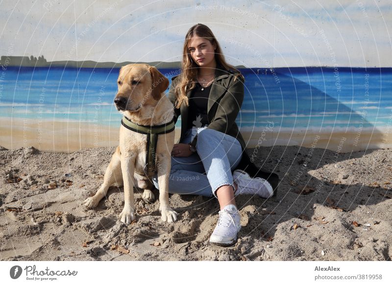 Blond girl and a blond Labrador sitting on a wall with graffiti on the beach Landscape Beach Intensive teen kind Nature feminine Uniqueness Exceptional