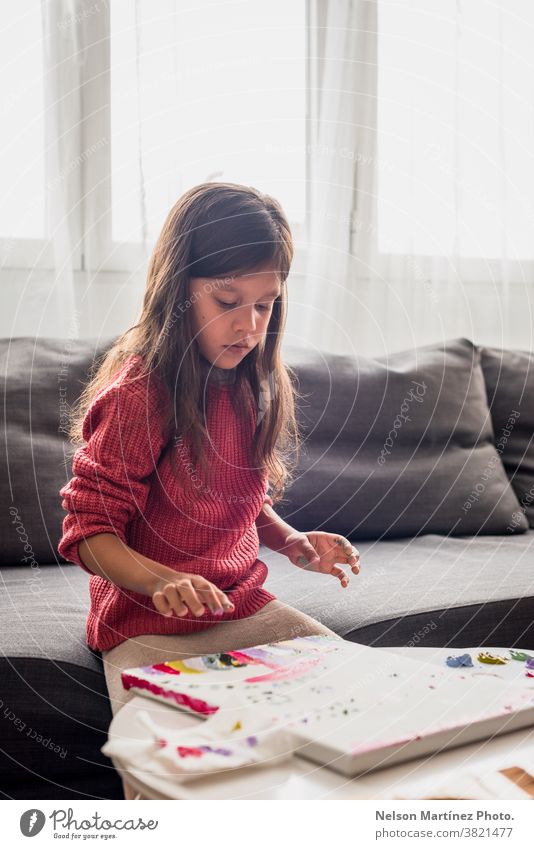 Beautiful little girl panting on a Canvas with her fingers. colours childhood smile art funny draw creativity learning beautiful paint happy education white