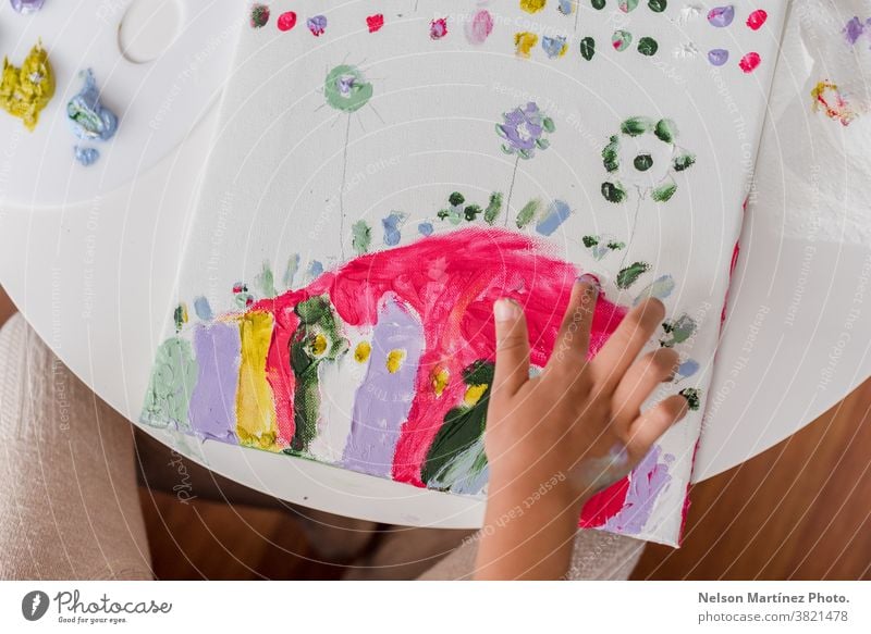 Hands of a little girl panting in a Canvas with her fingers. colours childhood smile art funny draw creativity learning beautiful paint happy education white