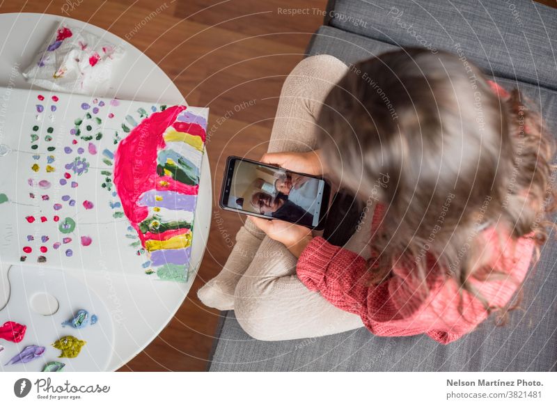 Little Kid holding a smartphone while she is chatting with her grandfather in the cell phone. greeting funny skype care call talking happy hallo online family
